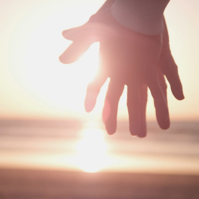 End of Life Care Jansen, Two hands holding another in front of a sunset beach