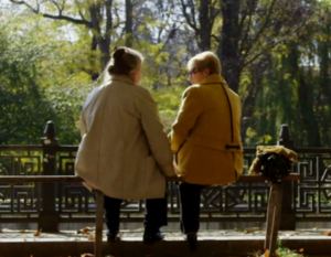 Two women holding hand outside