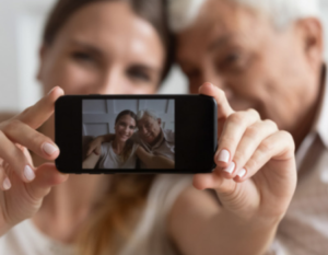 Young women and an older man taking a selfie